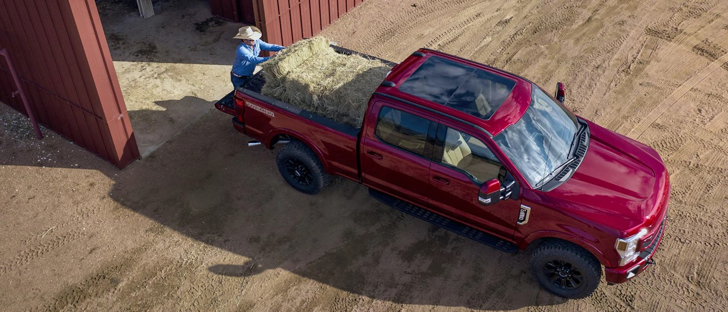 A farmer using a Ford Super Duty to haul hay.