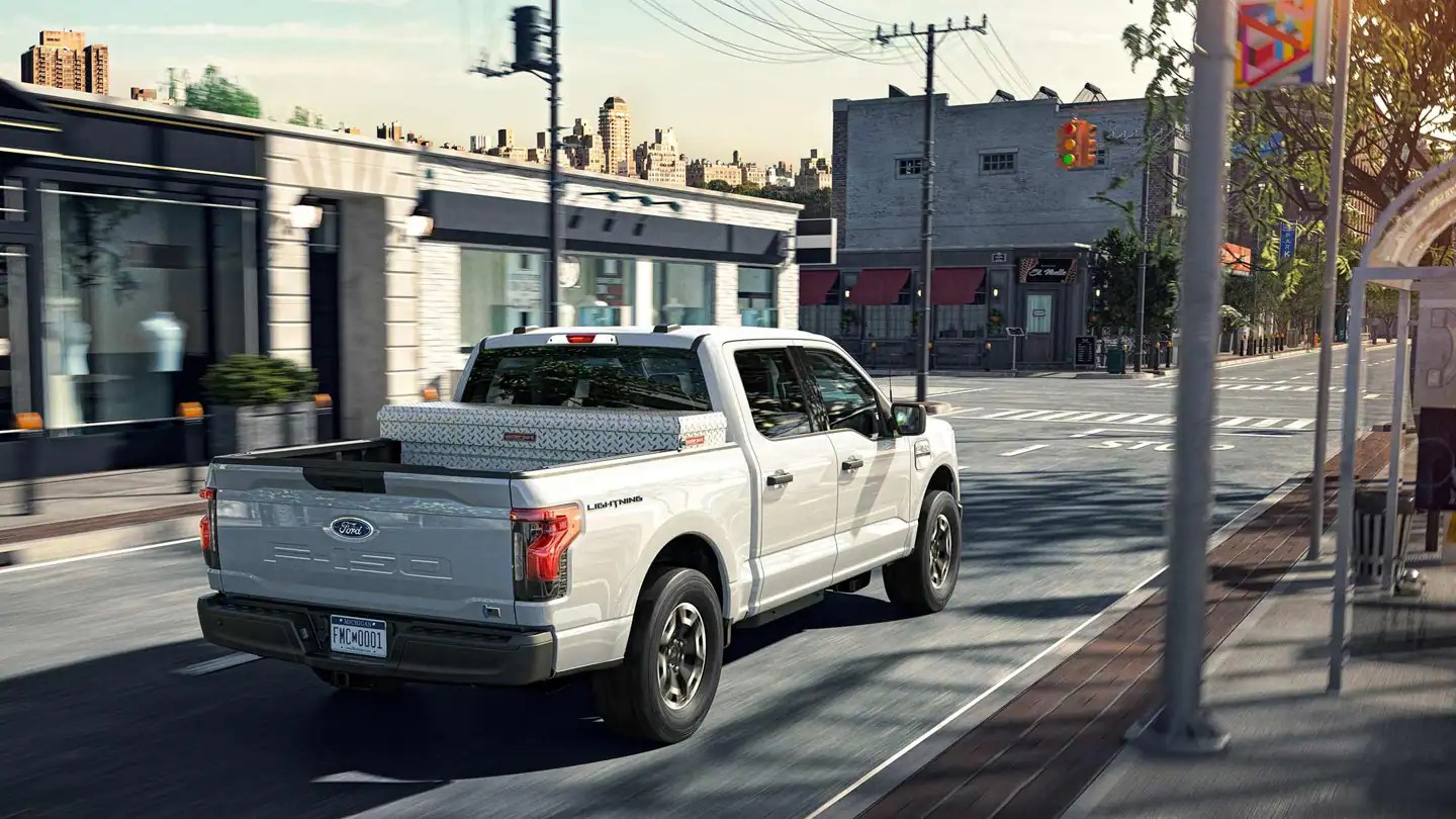 Ford F-150 Lightning Pro driving through a bustling city center in North Carolina.