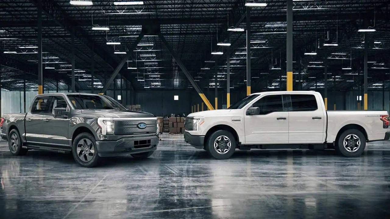 Dark grey and white Ford F-150 Lightning Pros parked inside a warehouse in North Carolina.